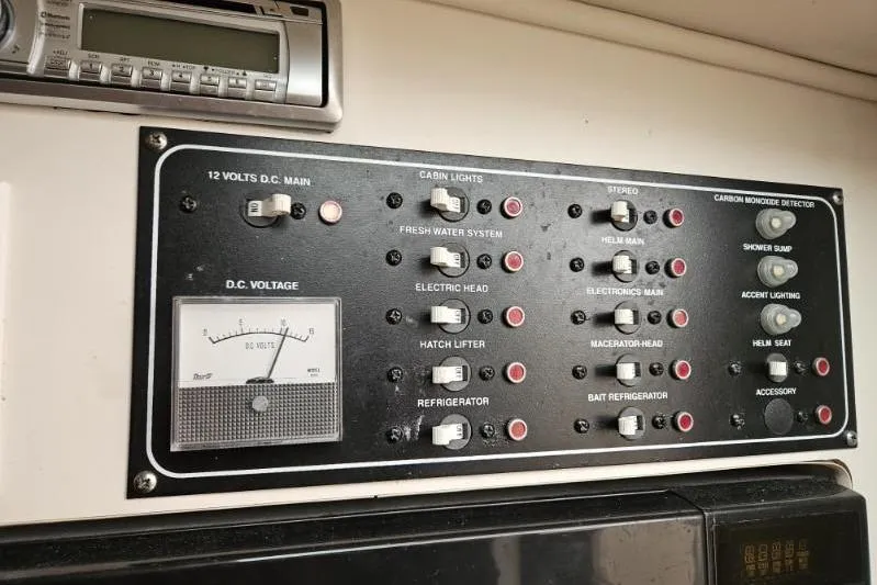 Slide: The Image of Control panel of a 2000 Pursuit 3070 Offshore Center Console boat with various switches and gauges. - 9