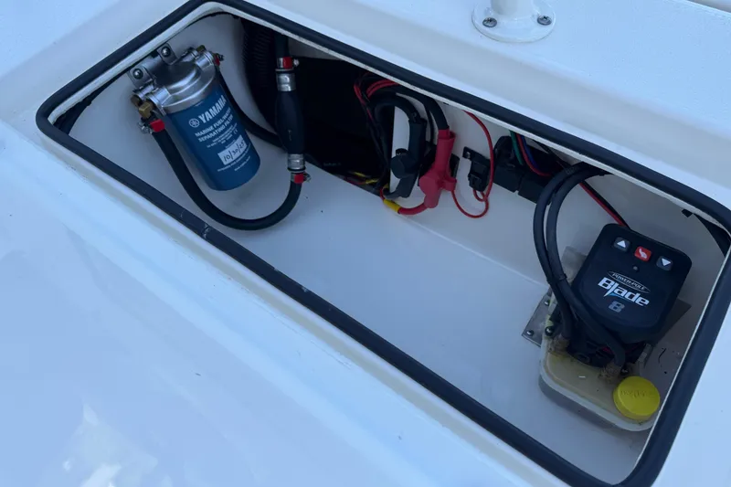 Slide: The Image of 2022 Hewes Redfisher 18 boat compartment with Yamaha marine fuel filter and electrical components. - 13