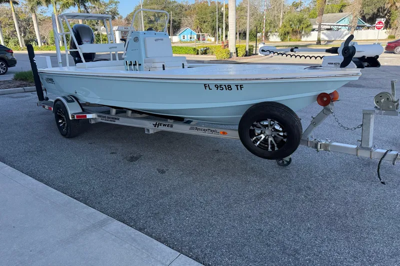 Slide: The Image of 2022 Hewes Redfisher 18 boat on trailer, parked outdoors, with visible registration number. - 2