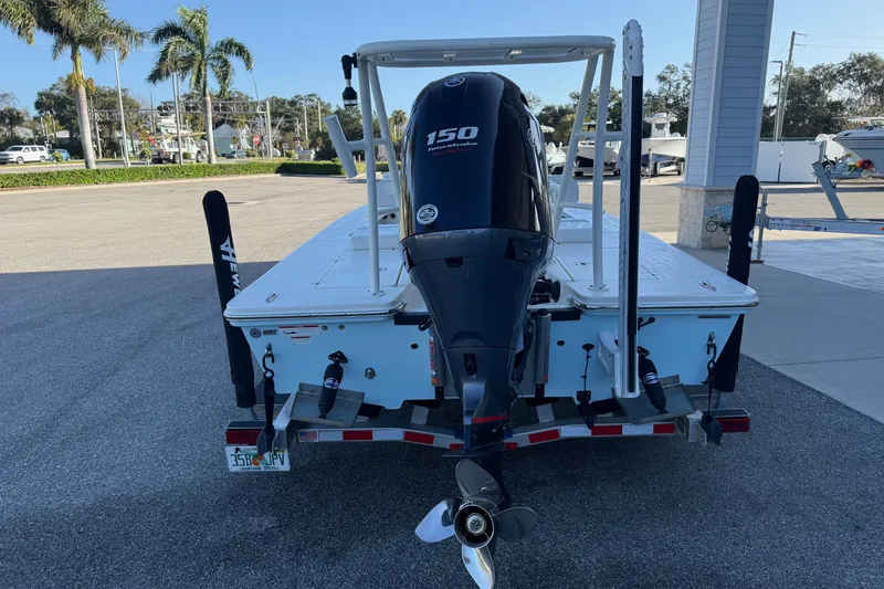 Slide: The Image of 2022 Hewes Redfisher 18 boat with 150 HP engine, parked outdoors. - 5