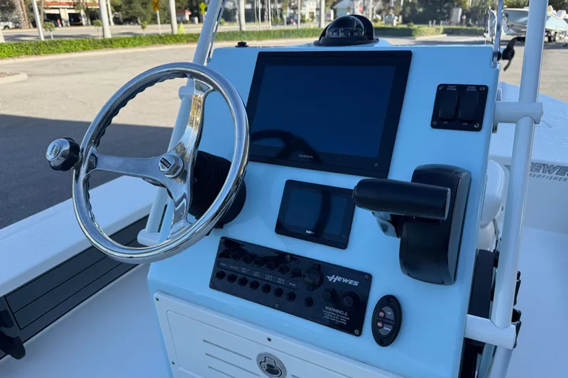 Slide: The Image of 2022 Hewes Redfisher 18 boat console with steering wheel and navigation equipment. - 6