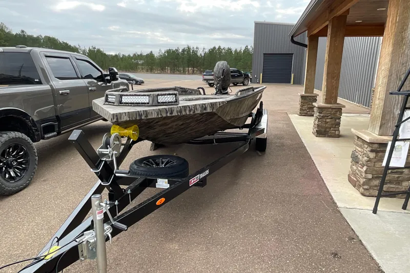 Slide: The Image of 2026 Excel Tomahawk 183 boat on trailer, parked beside a truck and building. - 3