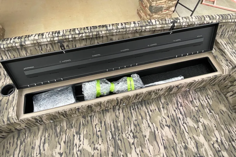 Slide: The Image of 2026 Excel Tomahawk 183 boat storage compartment with camouflage design and wrapped items inside. - 5
