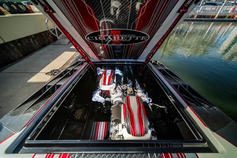 Slide: The Image of 2020 Cigarette 515 boat engine compartment with red and white detailing at a marina. - 6