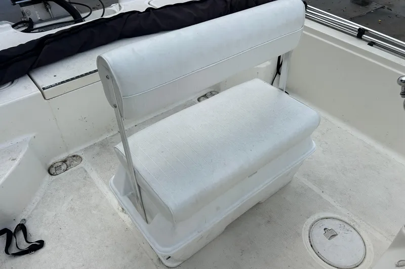 Slide: The Image of White seating on 2006 Triton 22 Bay Flight boat deck, featuring storage compartment. - 19