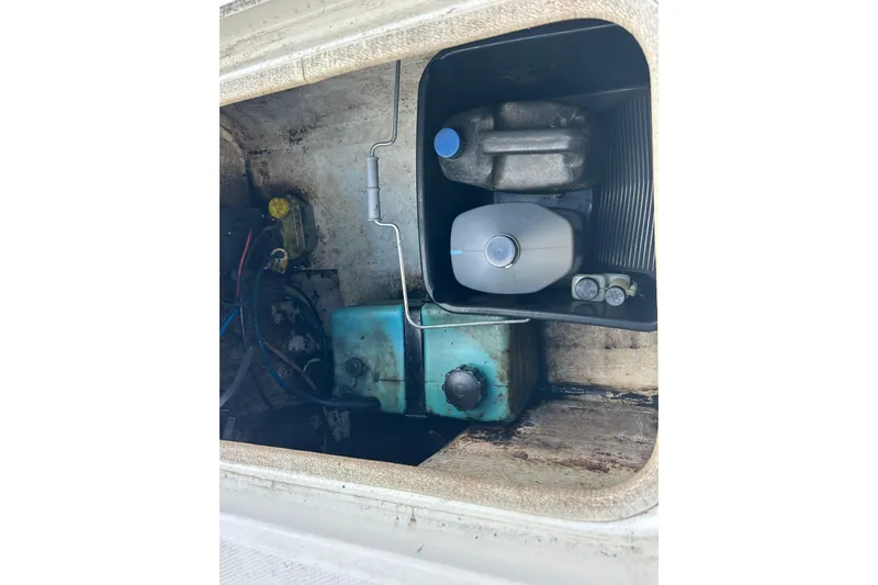 Slide: The Image of 2006 Triton 22 Bay Flight boat storage compartment with various containers and equipment. - 27