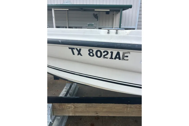 Slide: The Image of 2006 Triton 22 Bay Flight boat with registration TX 8021AE, docked near an office. - 31
