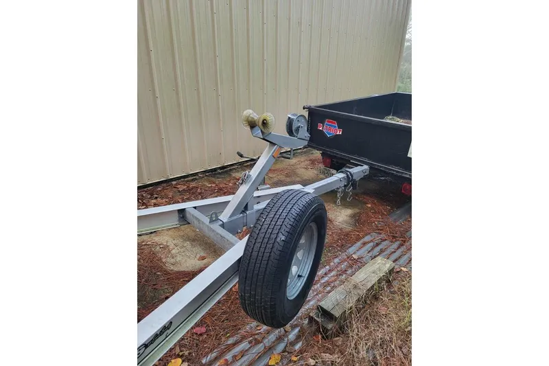 Slide: The Image of Trailer for 2006 Triton 22 Bay Flight boat, parked beside a metal building. - 33