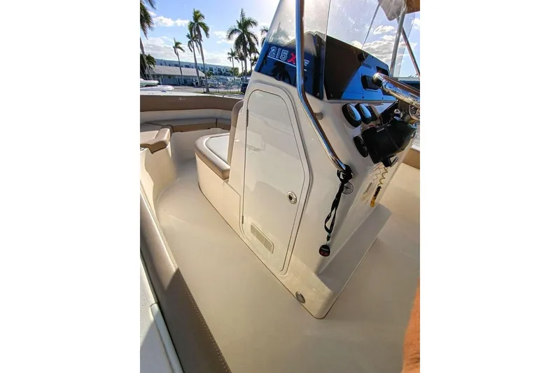 Slide: The Image of 2024 Scout 215 XSF boat interior with helm, seating, and controls under sunny skies. - 14