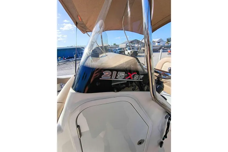 Slide: The Image of 2024 Scout 215 XSF boat console with windshield and outdoor background. - 16