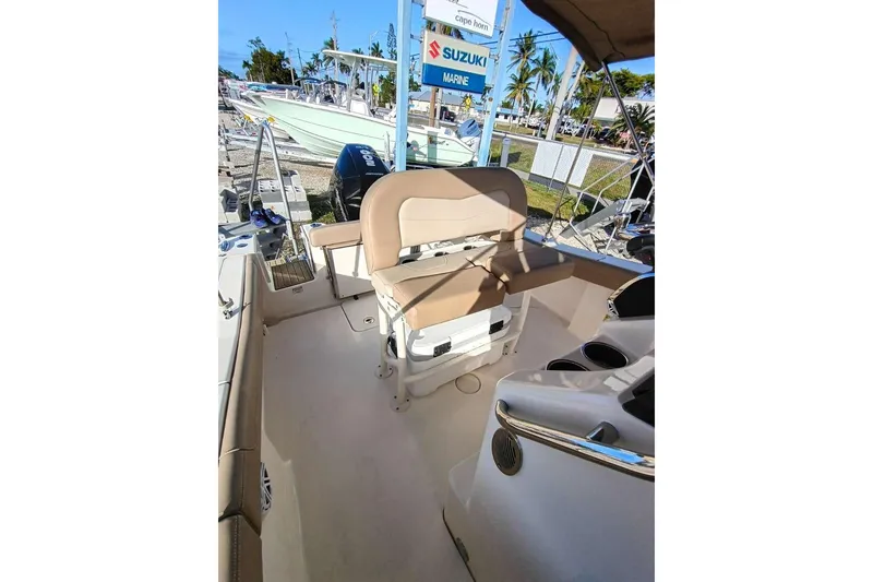 Slide: The Image of 2024 Scout 215 XSF boat interior with seating and Suzuki engine in a marina setting. - 27