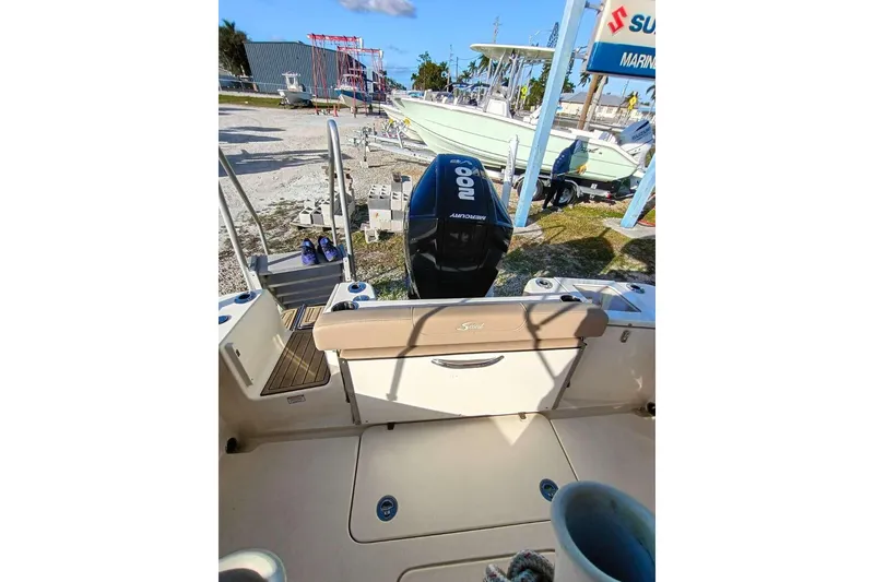 Slide: The Image of 2024 Scout 215 XSF boat with Mercury engine, parked outdoors at a marina. - 28