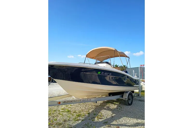 Slide: The Image of 2024 Scout 215 XSF boat on trailer under clear blue sky. - 3