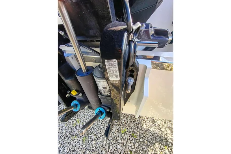 Slide: The Image of 2024 Scout 215 XSF boat engine detail with hydraulic components on gravel surface. - 34