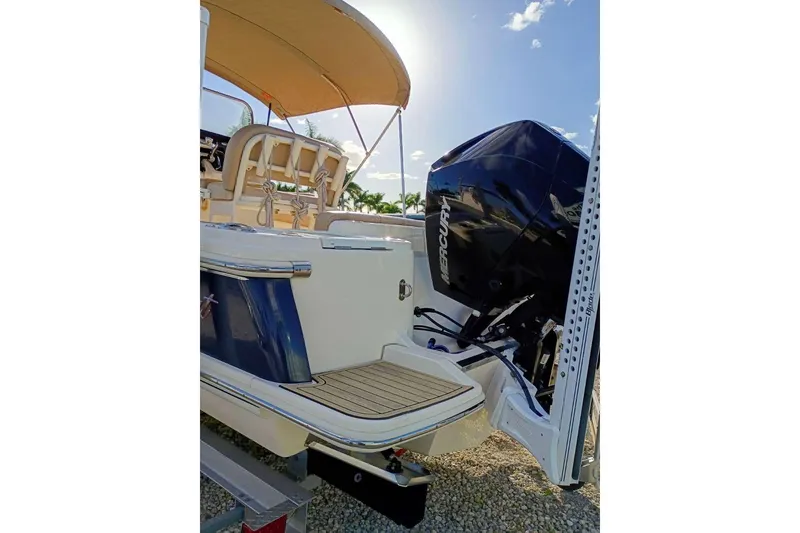 Slide: The Image of 2024 Scout 215 XSF boat with Mercury engine, rear view under sunny sky. - 4
