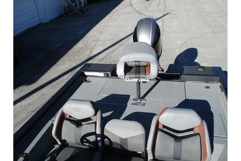 Slide: The Image of 2022 G3 Sportsman 1710 boat interior with seating and motor, parked on pavement. - 12