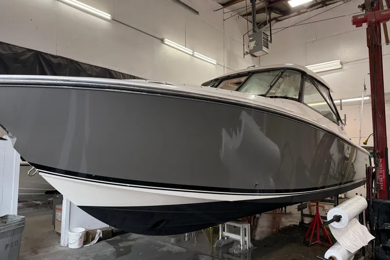 The Image of 2018 Pursuit DC 325 Dual Console boat in indoor storage facility. - 0