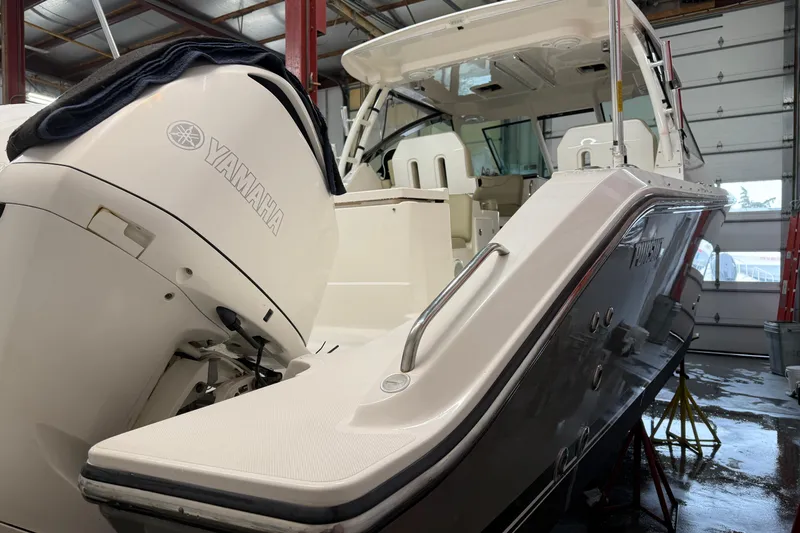 Slide: The Image of 2018 Pursuit DC 325 Dual Console boat with Yamaha engine in a garage. - 13