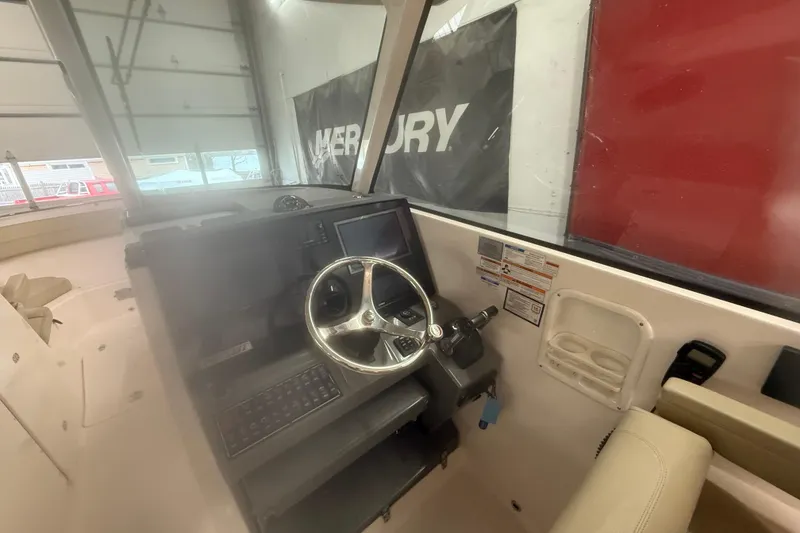 Slide: The Image of 2018 Pursuit DC 325 Dual Console boat interior with steering wheel and control panel. - 4