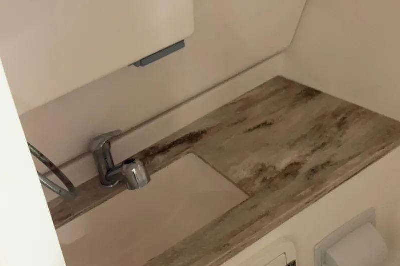 Slide: The Image of Interior view of 2018 Pursuit DC 325 Dual Console boat's compact sink area. - 9