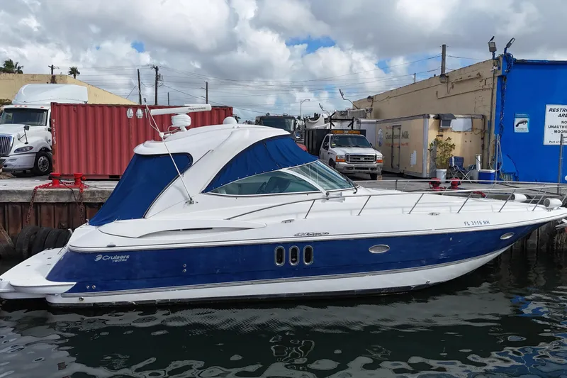 The Image of 2007 Cruisers Yachts 420 Express docked at marina, blue and white exterior. - 0