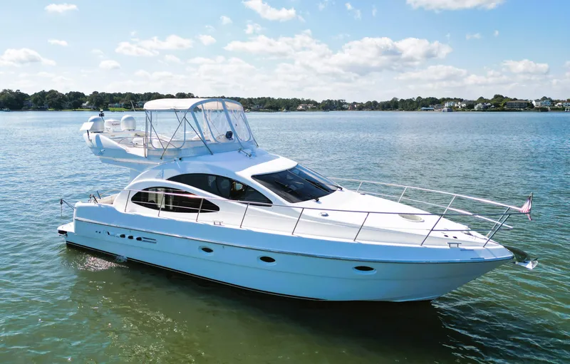 The Image of 2002 Azimut 42 yacht cruising on a calm lake under a clear sky. - 0