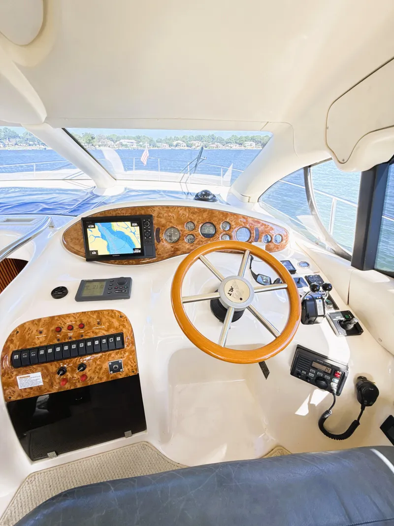 Slide: The Image of Interior view of 2002 Azimut 42 yacht cockpit with navigation controls and wooden steering wheel. - 16