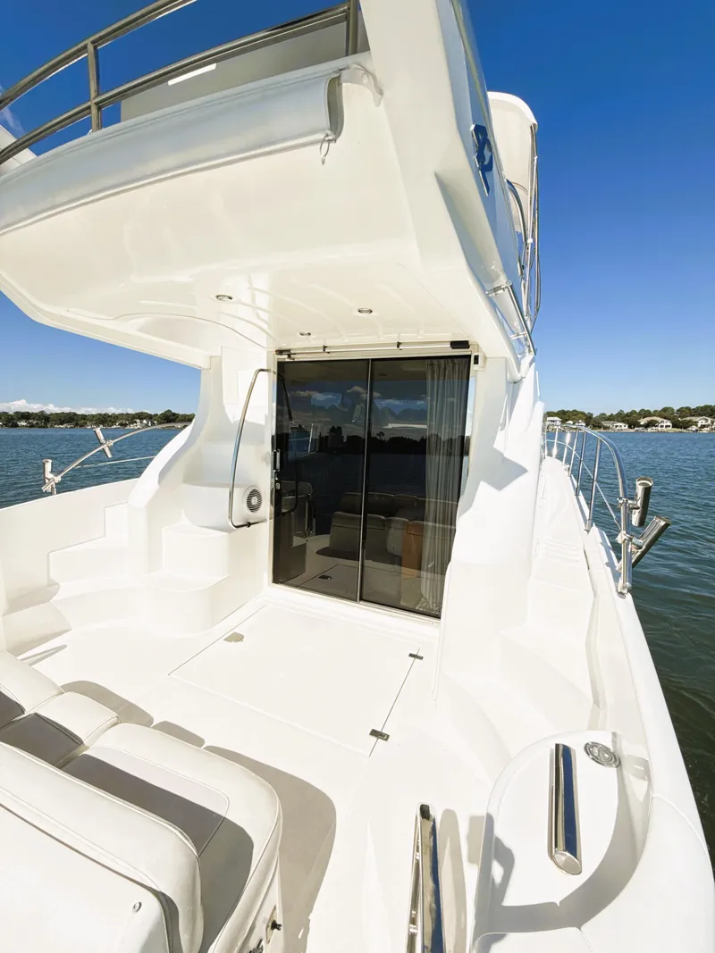 Slide: The Image of 2002 Azimut 42 yacht, sleek white deck, glass doors, sunny day on the water. - 22