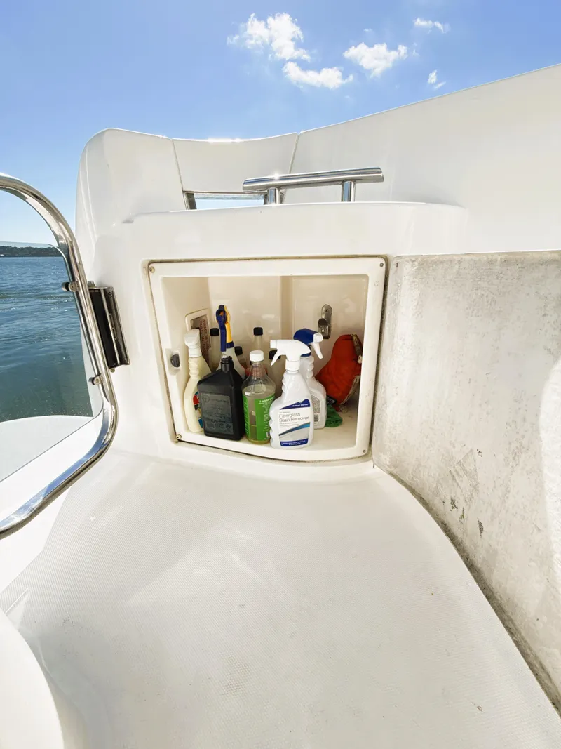 Slide: The Image of Storage compartment on 2002 Azimut 42 yacht with cleaning supplies, under clear blue sky. - 37