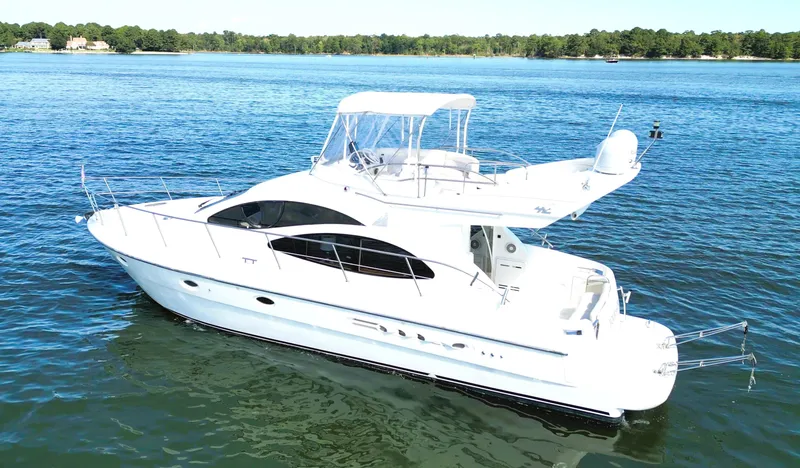 Slide: The Image of 2002 Azimut 42 yacht cruising on a serene lake under clear skies. - 5