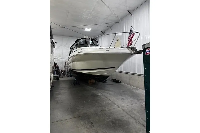 Slide: The Image of 2006 Sea Ray 320 Sundancer boat stored indoors with American flag. - 1
