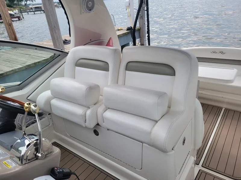 Slide: The Image of 2006 Sea Ray 320 Sundancer cockpit with white leather seats and waterfront view. - 16