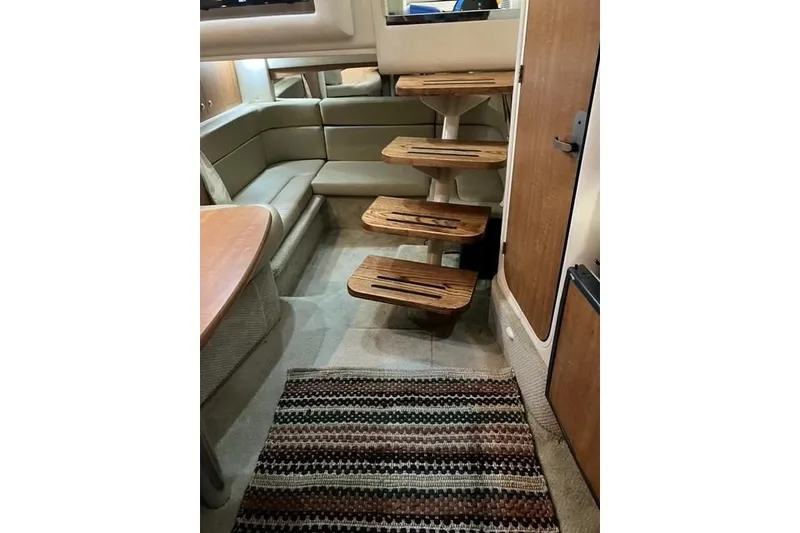 Slide: The Image of 2006 Sea Ray 320 Sundancer interior with wooden steps and cozy seating area. - 20