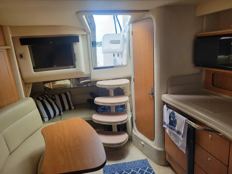 Slide: The Image of Interior of 2006 Sea Ray 320 Sundancer with seating, table, and kitchenette. - 25