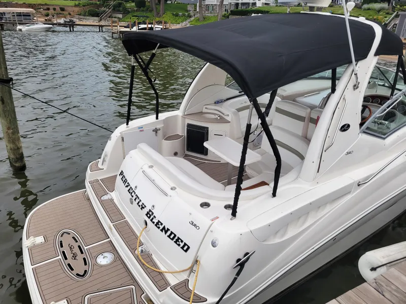Slide: The Image of 2006 Sea Ray 320 Sundancer boat docked with black canopy and spacious deck. - 3