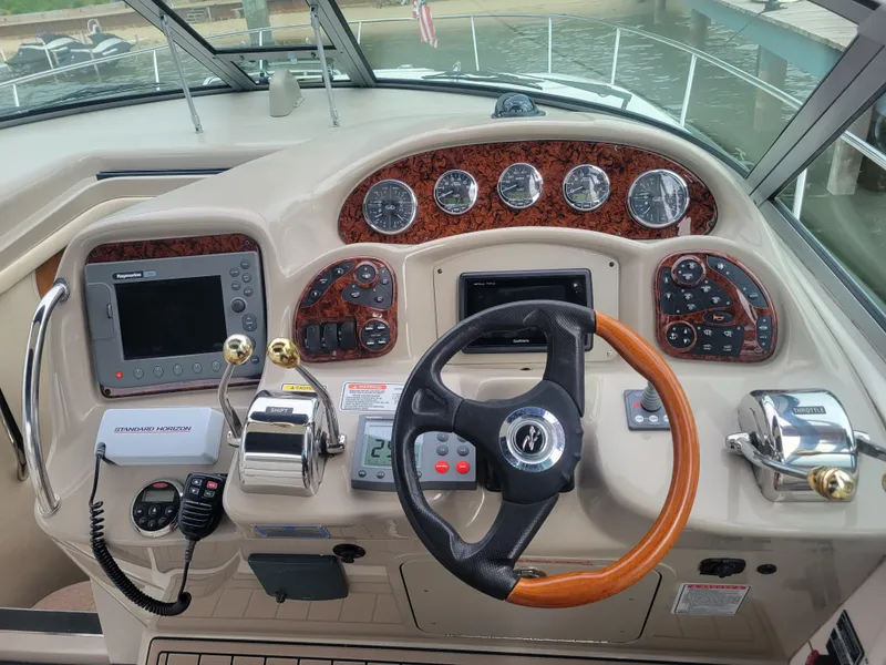 Slide: The Image of 2006 Sea Ray 320 Sundancer helm with steering wheel, gauges, and navigation equipment. - 8