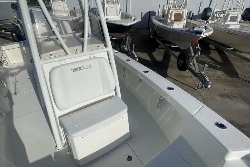 Slide: The Image of 2026 Pathfinder 2400 Open boat interior with seating and console, parked on a trailer. - 15
