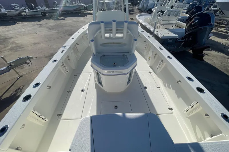 Slide: The Image of 2026 Pathfinder 2400 Open boat interior, featuring spacious deck and seating in a marina setting. - 16