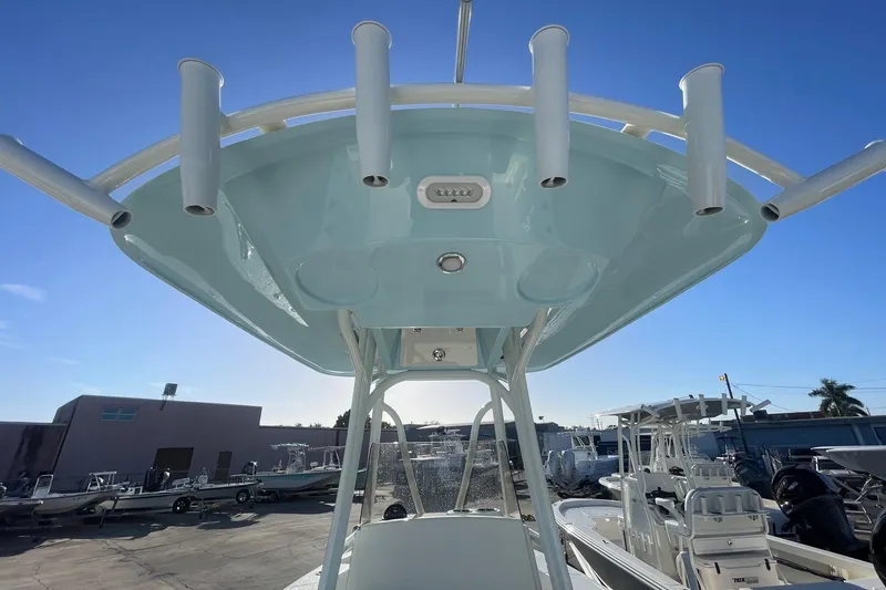 Slide: The Image of 2026 Pathfinder 2400 Open boat with T-top and rod holders under clear blue sky. - 17