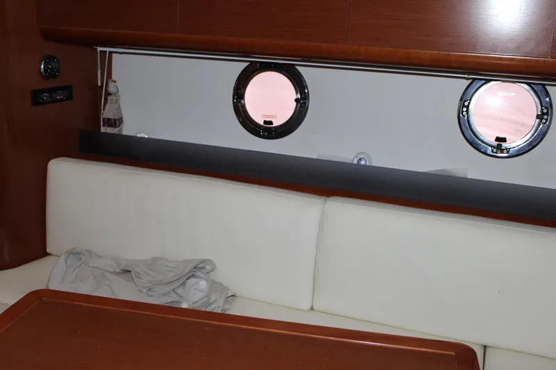 Slide: The Image of Interior of 2012 Beneteau Gran Turismo 38 yacht with white seating and portholes. - 19