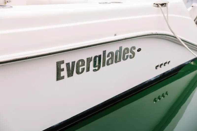 Slide: The Image of 2010 Everglades 350LX boat side view with logo, docked on water. - 12
