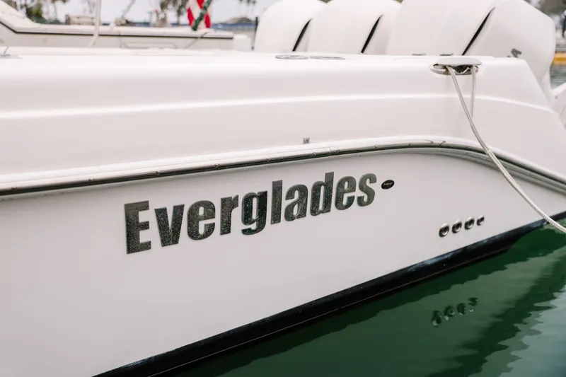 Slide: The Image of 2010 Everglades 350LX boat side view with logo, docked on calm water. - 13