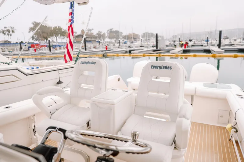 Slide: The Image of 2010 Everglades 350LX boat interior with white seating at marina. - 23
