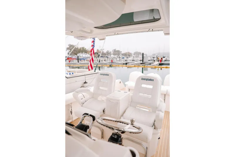 Slide: The Image of Interior of 2010 Everglades 350LX boat with white seating at marina. - 24
