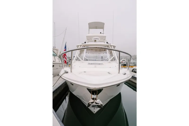 Slide: The Image of 2010 Everglades 350LX boat docked, front view, overcast sky, marina setting. - 3