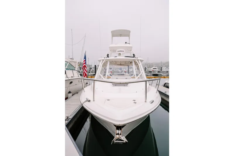 Slide: The Image of 2010 Everglades 350LX boat docked in a marina, front view with American flag. - 4
