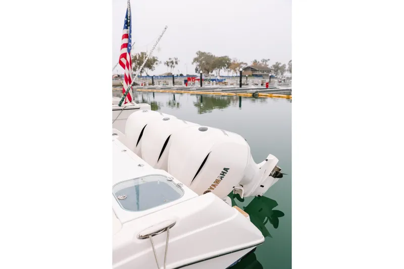 Slide: The Image of 2010 Everglades 350LX boat with Yamaha engines docked, American flag visible. - 8