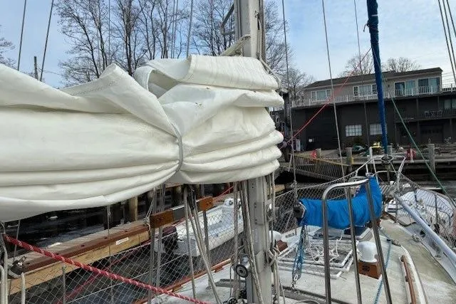 Slide: The Image of 1986 Tayana 37 sailboat with furled sails docked at a marina. - 19