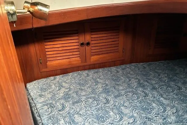 Slide: The Image of Cozy cabin interior of 1986 Tayana 37 sailboat with wooden cabinets and patterned bedding. - 20