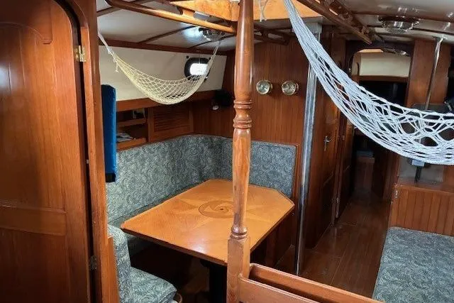Slide: The Image of Interior of 1986 Tayana 37 sailboat with wooden dining area and hammock. - 22